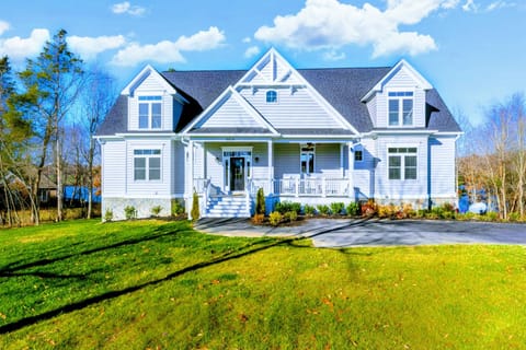 Elegant, spacious home with a charming front porch and beautifully manicured lawn