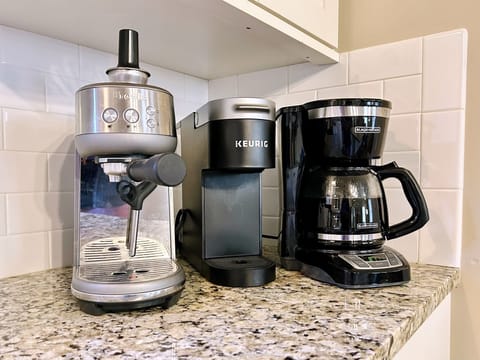 KCup machine, drip pot, bean grinder, espresso machine, and plenty of mugs
