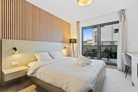 Inviting Living and Sleeping Space – Unwind in a cozy area featuring a queen-sized bed and a sophisticated wooden accent wall.