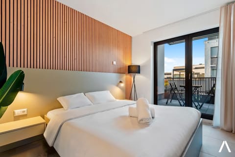 Inviting Living and Sleeping Space – Unwind in a cozy area featuring a queen-sized bed and a sophisticated wooden accent wall.