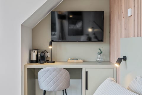 Functional Workspace and Entertainment Area – Wall-mounted TV, small desk, and a cozy chair create a perfect blend of comfort and productivity.