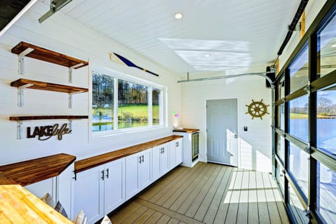 Bright and stylish lake-themed interior with ample counter space, nautical decor, and large windows for a perfect indoor-outdoor vibe