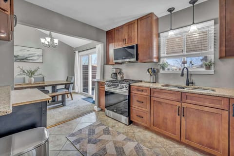 Enjoy a warm and inviting kitchen with sleek appliances, rich wood cabinetry, and an open flow into the dining area.