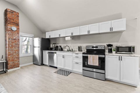 A brand-new kitchen with modern appliances, sleek cabinets, and stylish countertops, seamlessly integrated into the open-concept living area.