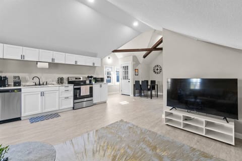 An open-concept living space that combines the kitchen, dining, and living room, all bathed in an abundance of natural light.