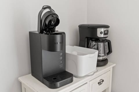 This cozy kitchen features a window that fills the space with natural light, a coffee maker for your daily brew, and a perfect view to enjoy while you cook.