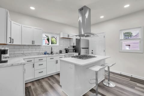 Enjoy the convenience of a center island with a burner, a modern sink, and a spacious fridge, all set in an elegantly designed kitchen for a functional and stylish cooking experience.
