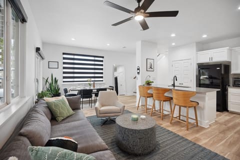 Open-Concept Living Space: A spacious, sunlit area with high-end furnishings and a smart TV for group entertainment. Enjoy the privacy shades at night.