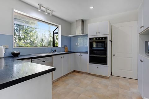 The kitchen has a oven, cooktop, microwave and dishwasher.