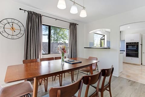 The dining room has a wooden table surrounded by matching wooden chairs.
