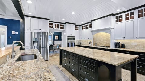 The gourmet kitchen offers a large kitchen island, ample counter space, and stainless steel appliances.