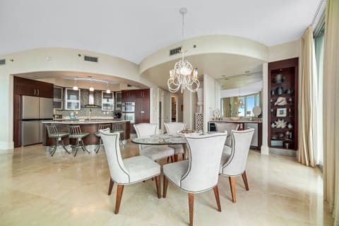 Dine in style with ample space for everyone. This inviting dining area features a charming table for family meals, complemented by additional seating at the convenient breakfast bar.