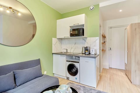 Pièce principale avec canapé lit, TV et cuisine