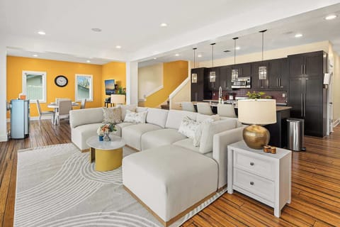 The living room seamlessly flows into the modern kitchen, creating a bright and open space perfect for socializing and relaxation. The living area features comfortable seating, while the kitchen boasts sleek countertops, modern appliances, and ample 