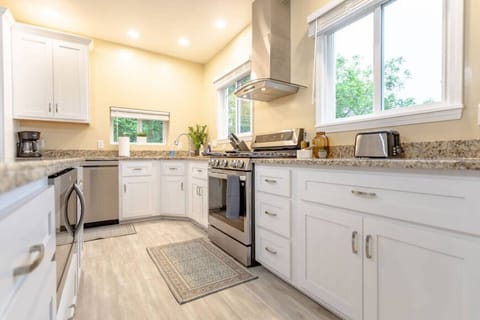 Cook your favorite meals in this bright, modern kitchen. Enjoy stainless steel appliances, ample counter space, & abundant storage. Windows flood the space with natural light, creating a warm, welcoming atmosphere perfect for any culinary adventure.