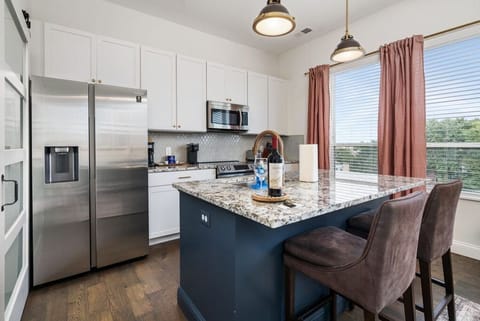 Full kitchen with tons of kitchenware and granite island and stainless steel finishes!