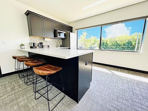 Enjoy the sleek, modern kitchen with a spacious island, elegant barstools, and large windows filling the space with natural light. Perfect for meals, drinks, or simply gathering with loved ones.