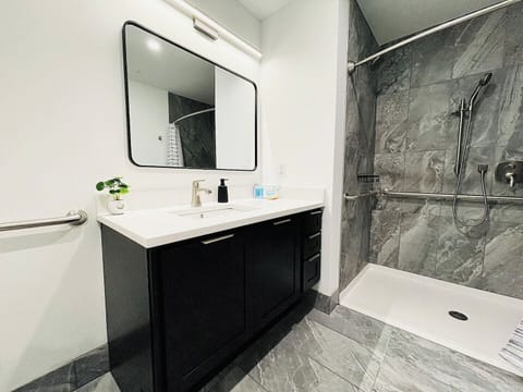 A sleek, modern bathroom with a spacious vanity, stylish lighting, and ample counter space. Spotlessly clean and well-lit, perfect for your stay.