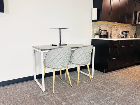 A modern desk setup with an ice bucket, lamp, and remotes, perfect for relaxing or getting work done during your stay.