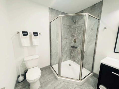A luxurious bathroom with a sleek vanity, a glass-enclosed shower, and plenty of plush towels for your comfort.