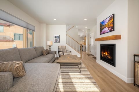 - Spacious living room is anchored by a cozy sectional sofa and large coffee table - Modern fireplace and mounted TV provide warmth and entertainment for your group - Soft lighting and neutral tones invite relaxation in this bright and open space