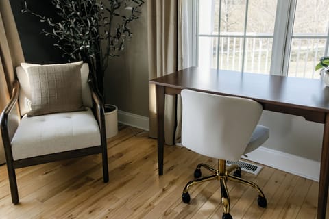 Work remotely at a stylish desk with bright light in this bedroom.