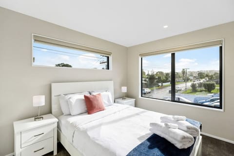 The fourth bedroom has white furniture and a blue throw with apricot cushion.