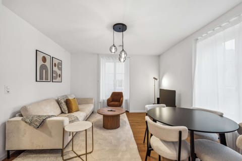 Bright and modern, this open-concept living space blends a cozy seating area with a chic dining nook, all bathed in natural light.