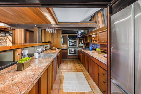 Cook in rustic elegance! This gourmet kitchen features rich wood cabinetry, granite countertops, and an open layout perfect for both everyday meals and entertaining.