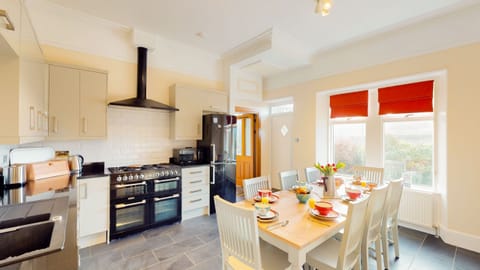 A bright and fully equipped modern kitchen with ample space for preparing meals and dining