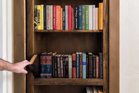 Book latch opens the bookshelf door that leads to a secret game room