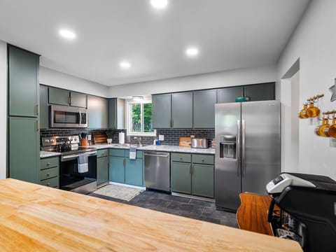 A thoughtfully designed kitchen, showcasing a harmonious blend of modern appliances and classic cabinetry.  The muted tones create a serene atmosphere.🏡