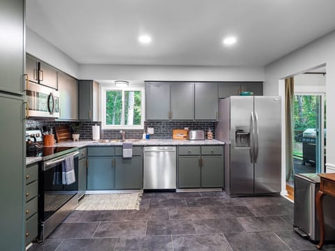 House one: A stunning kitchen with a modern and stylish touch! 🍽️✨ Featuring sleek green cabinetry, stainless steel appliances, and a chic black subway tile backsplash, this space is both functional and beautiful. 🌿💚 #KitchenGoals
