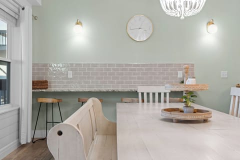 - Charming breakfast nook with a stone topped counter and rustic stools, perfect for coffee breaks
- Subway tile backsplash adds a touch of farmhouse chic and soft elegance
- Clock, sconces, and wall hues create a calm, modern country feel