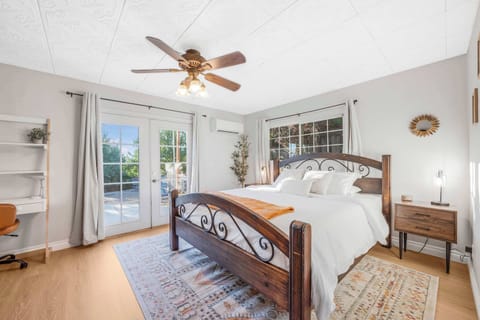 Plush king bed with French doors out to backyard