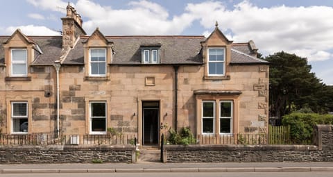 Dalgety - front garden with lawn and herbaceous border which is enclosed by a gate and wall