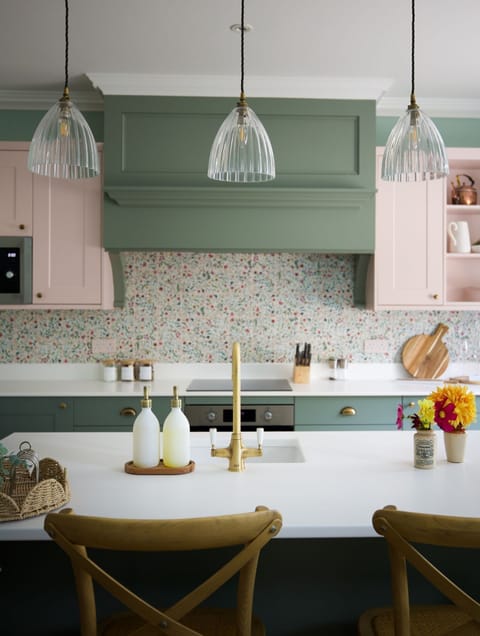 Stables Cottage - the colourful kitchen, decorated with whimsical floral tiles and brass fittings