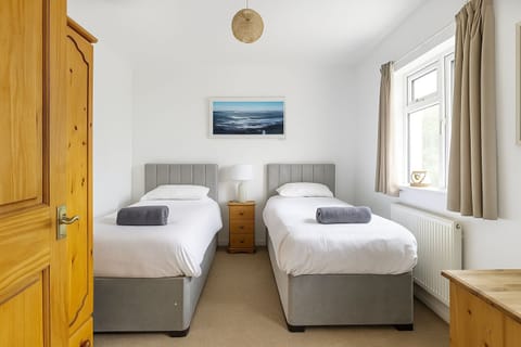 Bedroom Two has twin beds with bedside drawers and lamp