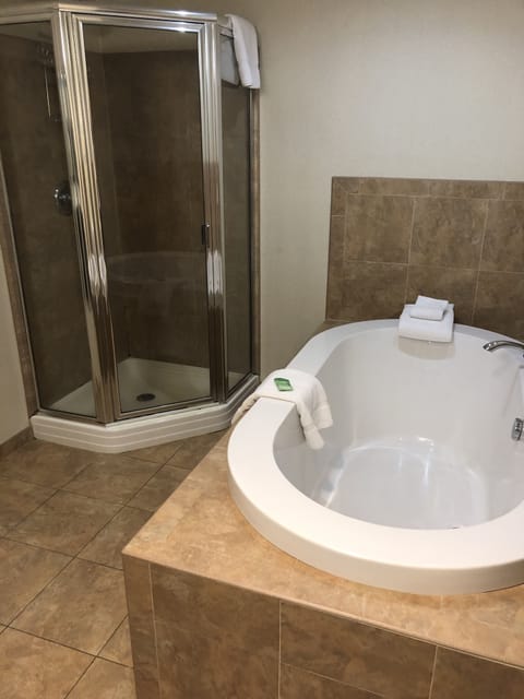 Suite, 1 King Bed (Soaking Tub) | Bathroom | Combined shower/tub, free toiletries, hair dryer, towels