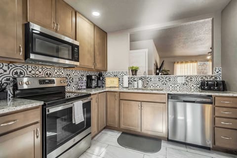 Cook with ease in the fully stocked kitchen, featuring modern appliances, ample counter space, and a stylish dining area perfect for enjoying meals together.