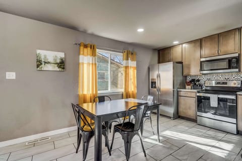 Gather around the dining table in this sunlit space, perfect for sharing meals, game nights, or a morning coffee.