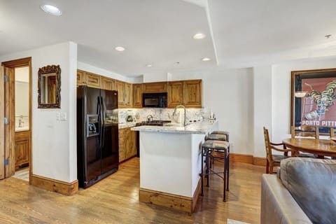 Open kitchen with wood finishes and bright lighting, ideal for gathering over meals.