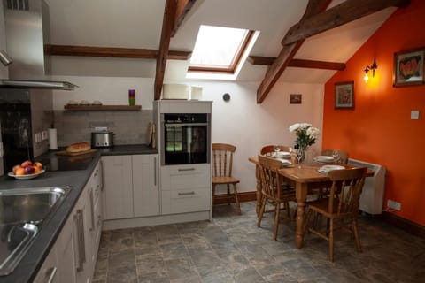 Kitchen/dining area with eye level oven and electric hob and extractor hood