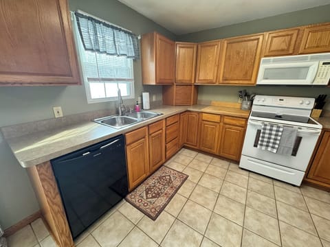 Fully stocked kitchen with dishwasher and electric stove.