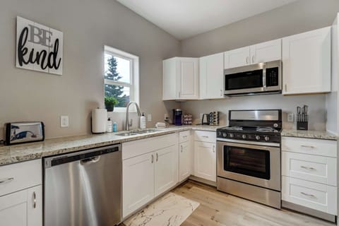 The fully equipped kitchen features modern appliances, a gas range, a dishwasher, and a coffee station with complimentary coffee and spices.
