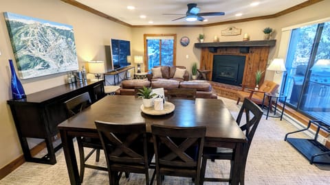 Living room with gas fireplace, dining table, and patio w/ propane BBQ grill