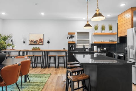 - Spacious dining table perfect for shared meals and game nights
- High-top bar with additional seating and fun “adventure” wall art
- Open-concept design flows effortlessly from kitchen to dining