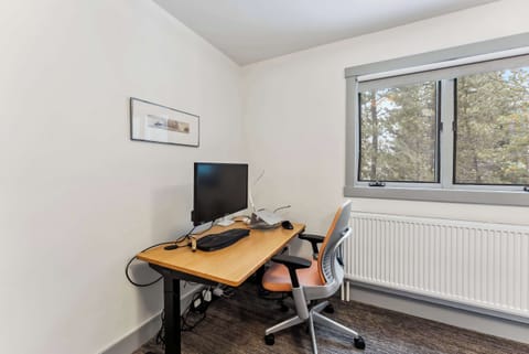 Bedroom 1: Queen bed, main floor, desk with monitor, small window with mountain view