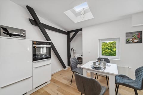 Die moderne Küche mit Dachfenster, Waschmaschine und gemütlichem Essbereich verbindet Funktionalität mit Charme.