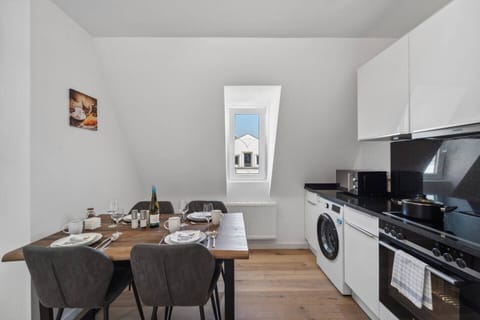 Die moderne Küche mit Essbereich bietet hochwertige Geräte, eine Waschmaschine und einen stilvoll gedeckten Tisch für gemeinsame Mahlzeiten.